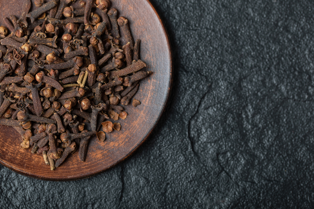 brown-plate-full-dried-cloves-dark-background (1) (1)